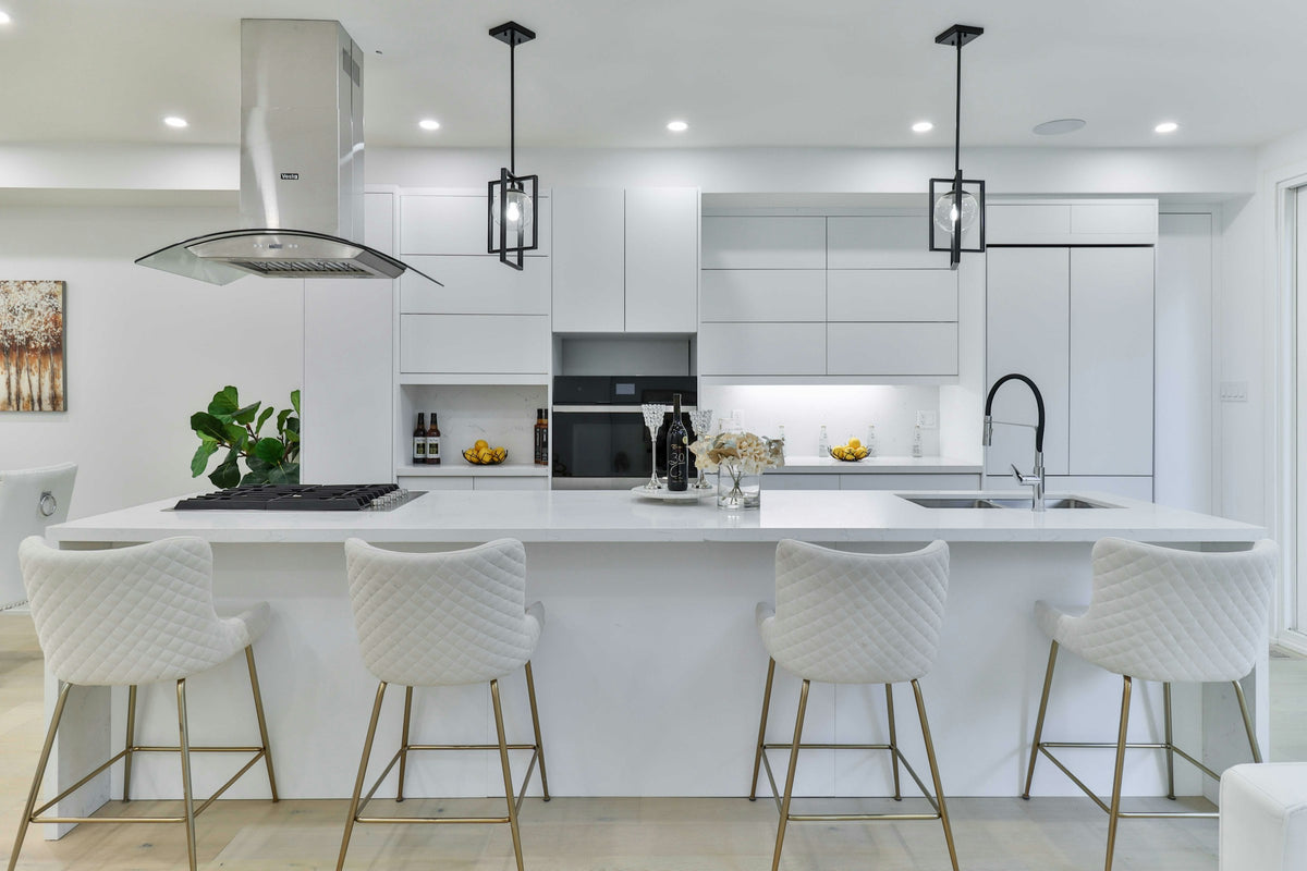 Cocina blanca con isla y taburetes